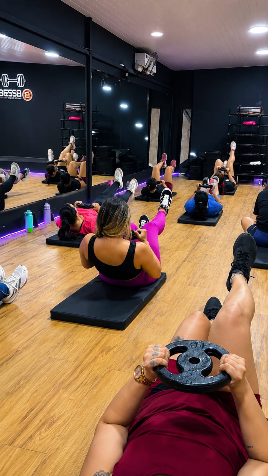 Turma de funcional fazendo abdominal com anilha na Bessa
