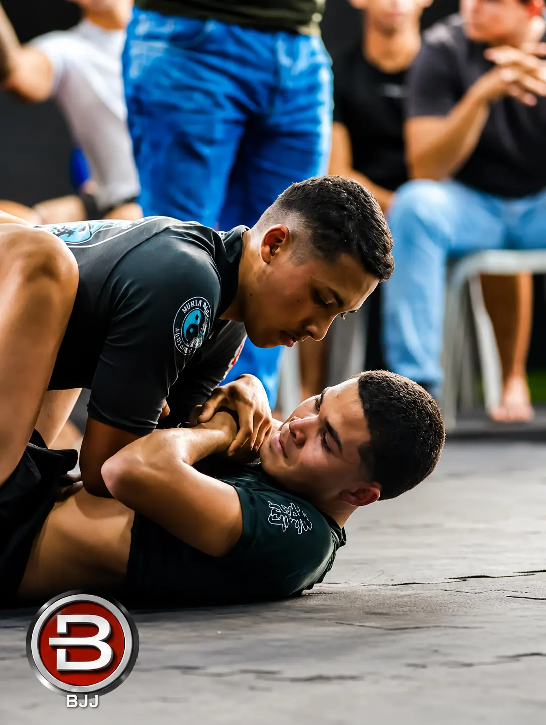 Treino de luta agarrada no chão com supervisão do professor
