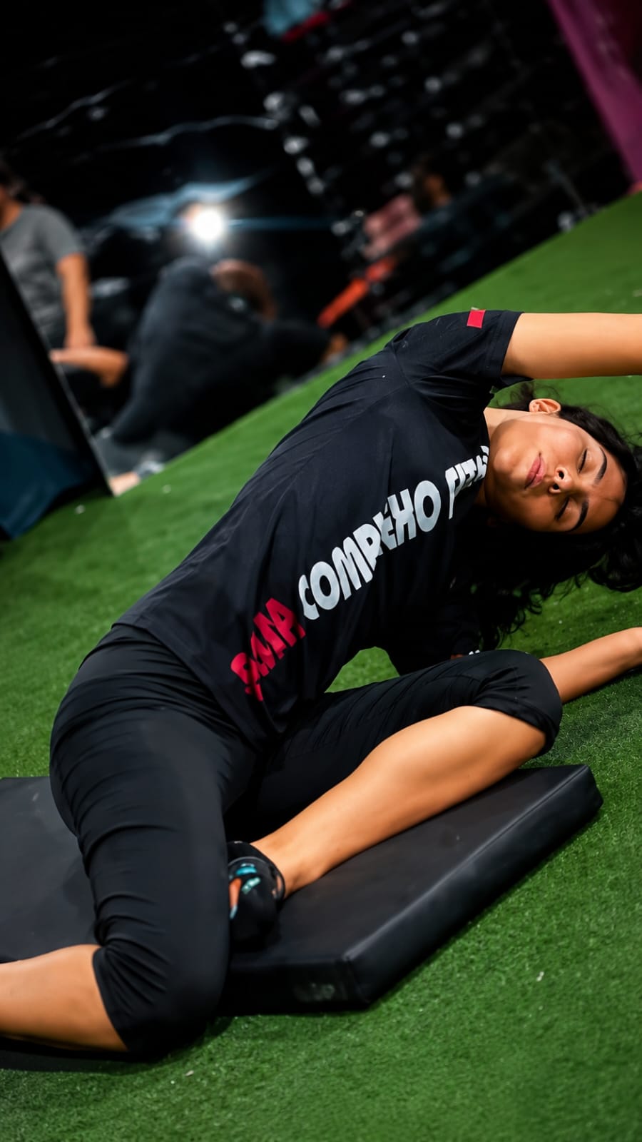Aluna da Bessa em alongamento no colchonete durante aula de pilates